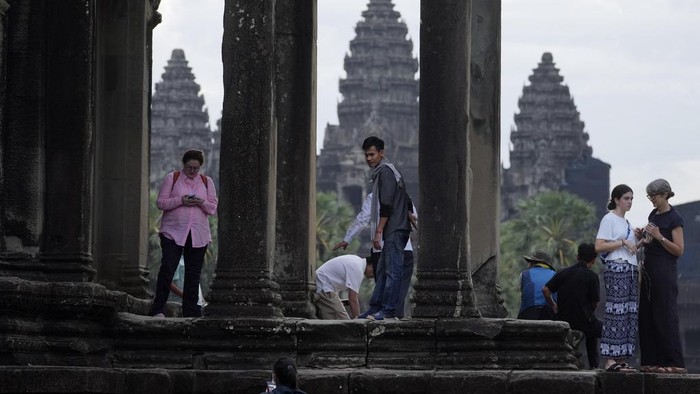 Tourists visit the Angkor Wat temple in Siem Reap province, Cambodia, Friday, Aug. 2, 2024. A centuries-old Angkor temple complex that sprawls across some 400 square kilometers (155 square miles), containing the ruins of capitals of various Cambodian empires from the 9th to the 15th century is the countrys most popular tourist attraction and in the first half of this year attracted more than half a million international tourists. (AP Photo/Heng Sinith)