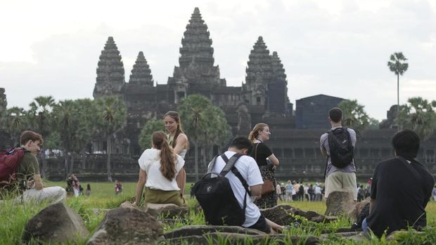 Tourists visit the Angkor Wat temple in Siem Reap province, Cambodia, Friday, Aug. 2, 2024. A centuries-old Angkor temple complex that sprawls across some 400 square kilometers (155 square miles), containing the ruins of capitals of various Cambodian empires from the 9th to the 15th century is the country's most popular tourist attraction and in the first half of this year attracted more than half a million international tourists. (AP Photo/Heng Sinith)