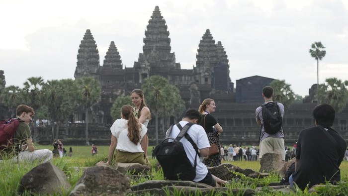 Potret Ramainya Turis Kunjungi Angkor Wat Tourists visit the Angkor Wat temple in Siem Reap province, Cambodia, Friday, Aug. 2, 2024. A centuries-old Angkor temple complex that sprawls across some 400 square kilometers (155 square miles), containing the ruins of capitals of various Cambodian empires from the 9th to the 15th century is the country's most popular tourist attraction and in the first half of this year attracted more than half a million international tourists. (AP Photo/Heng Sinith)