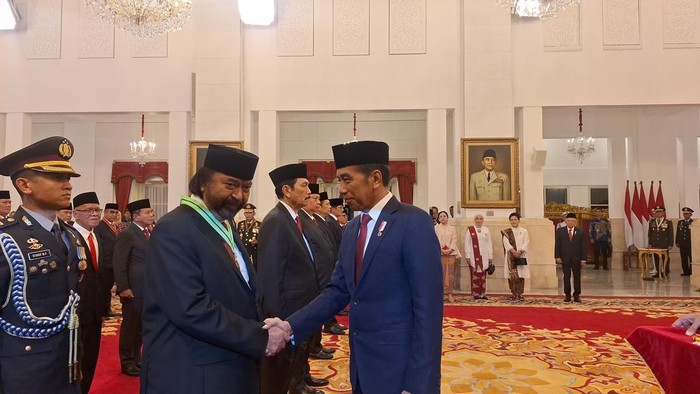 Presiden Joko Widodo (kanan) memberikan tanda jasa kehormatan yakni Medali Kepeloporan kepada Ketua Umum Partai NasDem Surya Paloh (kiri).