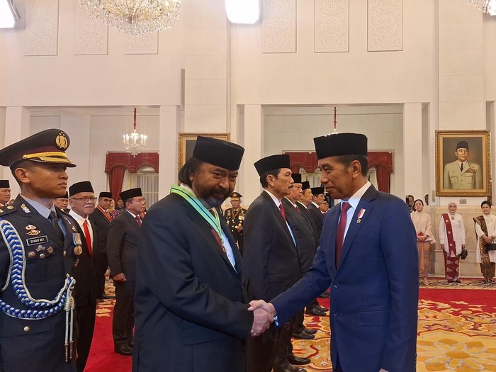 Presiden Joko Widodo (kanan) memberikan tanda jasa kehormatan yakni Medali Kepeloporan kepada Ketua Umum Partai NasDem Surya Paloh (kiri).