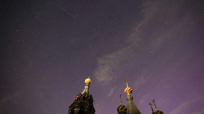 In this photo taken with long shutter speed, northern lights, or aurora borealis, are seen above the Church of the Nativity of Christ in Gololobovo village in Moscow region, Russia, Tuesday, Aug. 13, 2024. (AP Photo/Pavel Bednyakov)