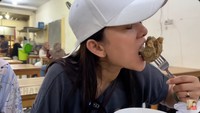 Shanty tampak begitu menikmati bakso urat yang dibelinya. Menurut Shanty, rasanya sangat enak dan uratnya juga begitu terasa. Foto: YouTube Shanty di China