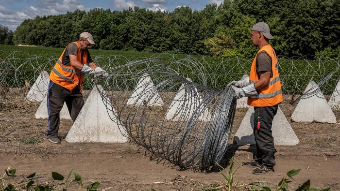 Ukraina Bangun Benteng Anti-tank di Dekat Perbatasan Rusia Workers install anti-tank fortifications, named 'dragon's teeth', and razor wire, amid Russia's attack on Ukraine, near the Russian border in Sumy region, Ukraine August 14, 2024. REUTERS/Viacheslav Ratynskyi