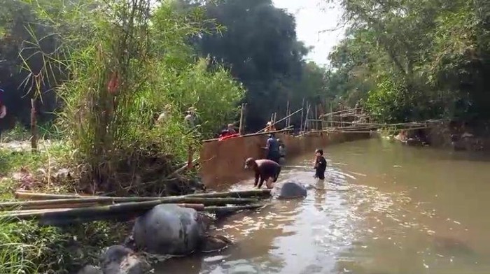 Warga saat membuat bendungan sungai dari bambu