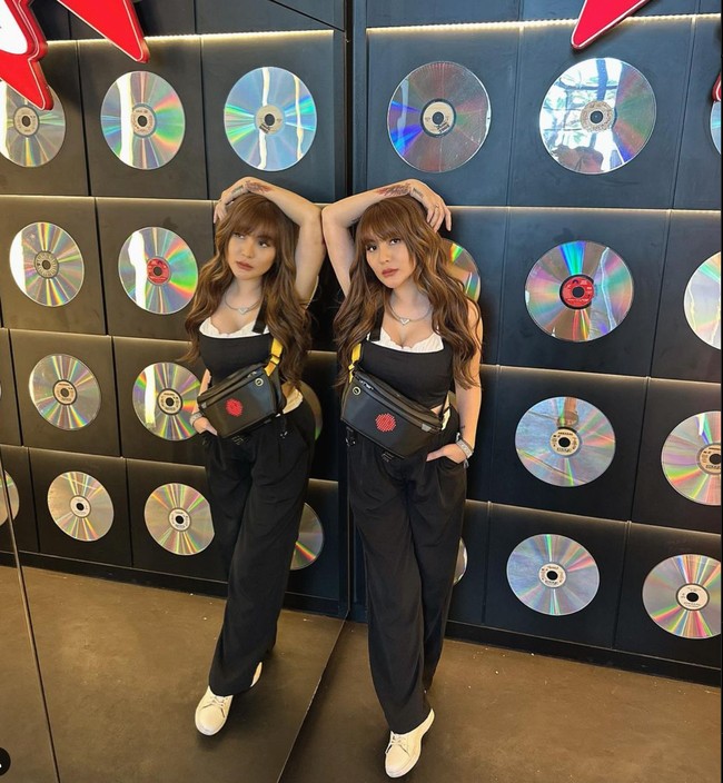 Jago berpose di depan kamera, begini potret Angela Lee saat mengenakan tanktop crop top hitam dipadukan dengan celana panjang hitam. Foto: Instagram/@angelalee87