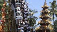 Para lelaki meletakkan jenazah kerabat mereka yang telah meninggal ke dalam menara atau bade selama kremasi massal tradisional yang disebut ngaben di Manggis, Bali, Rabu (14/8/2024).  