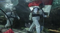 Penyelam mengibarkan bendera Merah Putih dalam gladi bersih memperingati HUT Ke-79 Kemerdekaan RI di Sea World Ancol, Jakarta, Kamis (15/8/2024).