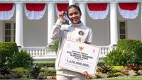 Gregoria Mariska Tunjung berfoto dengan medali perunggu dan plakat bonus yang diterimanya.