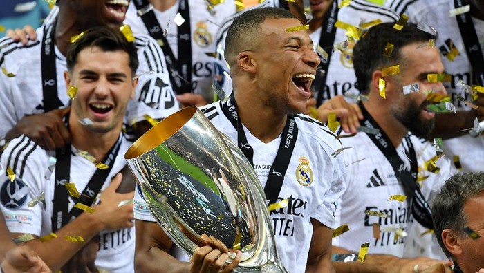 Soccer Football - Super Cup - Real Madrid v Atalanta - National Stadium, Warsaw, Poland - August 14, 2024 Real Madrids Kylian Mbappe celebrates with the trophy after winning the Super Cup REUTERS/Jennifer Lorenzini