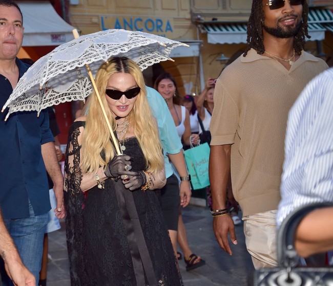 Di jajaran aksesori, Madonna turut melengkapi gayanya dengan kacamata hitam, sarung tangan fishnet, dan perhiasan tumpuk berupa kalung dan gelang, serta cincin berbatu besar. Tidak ketinggalan payung putih bergaya Victorian. (Foto: MEGA/GC Images via Getty Images)