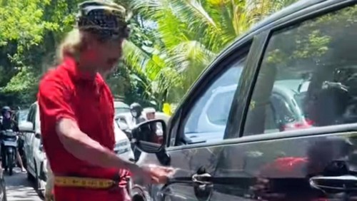 Mobil menerobos kemacetan saat upacara pengabenan di Desa Antiga, Kecamatan Manggis, Kabupaten Karangasem. (istimewa)
