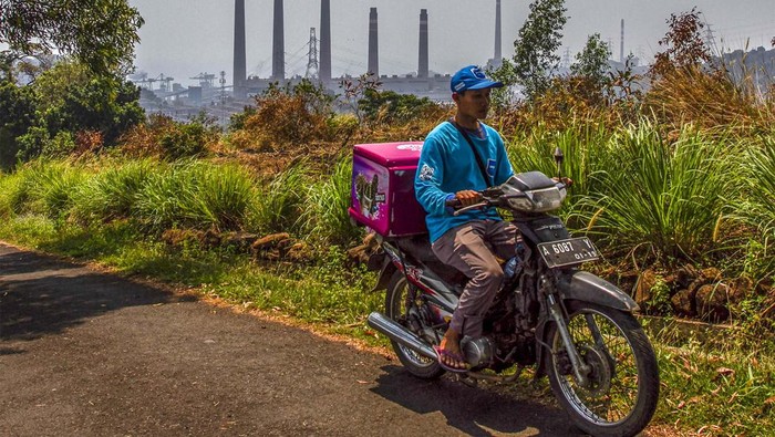 Pengendara sepeda motor melintas di sekitar PLTU Suralaya, Kota Cilegon, Banten, Kamis (15/8/2024). Menteri Koordinator Bidang Kemaritiman dan Investasi Luhut Binsar Pandjaitan mengatakan berencana akan menutup PLTU Suralaya yang sudah beroperasi selama lebih dari 40 tahun sebagai upaya pemerintah untuk mengatasi polusi udara di wilayah Jakarta. ANTARA FOTO/Angga Budhiyanto/gp/foc.
