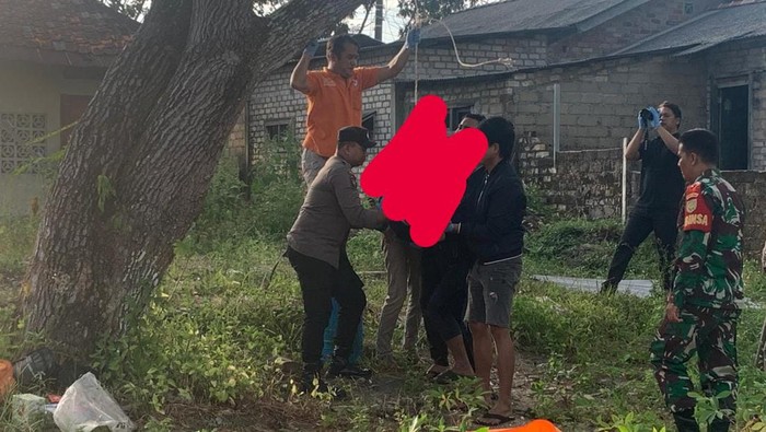 Petugas saat mengevakuasi korban usai bunuh diri di pohon dekat rumah