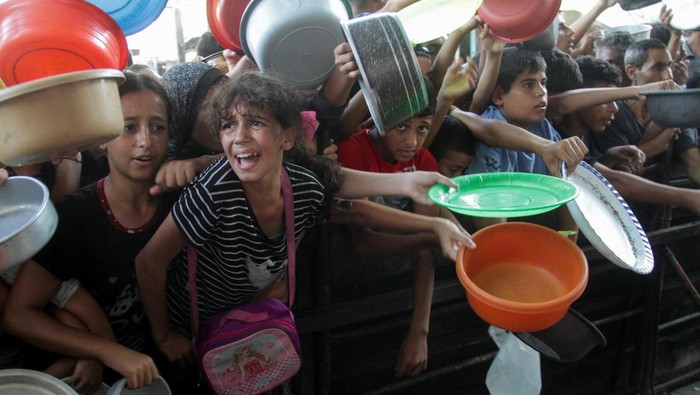 Potret Pilu Warga Palestina Antre Makanan Palestinians wait to receive food cooked by a charity kitchen, amid a hunger crisis as conflict between Israel and Hamas continues, in the northern Gaza Strip August 14, 2024. REUTERS/Mahmoud Issa