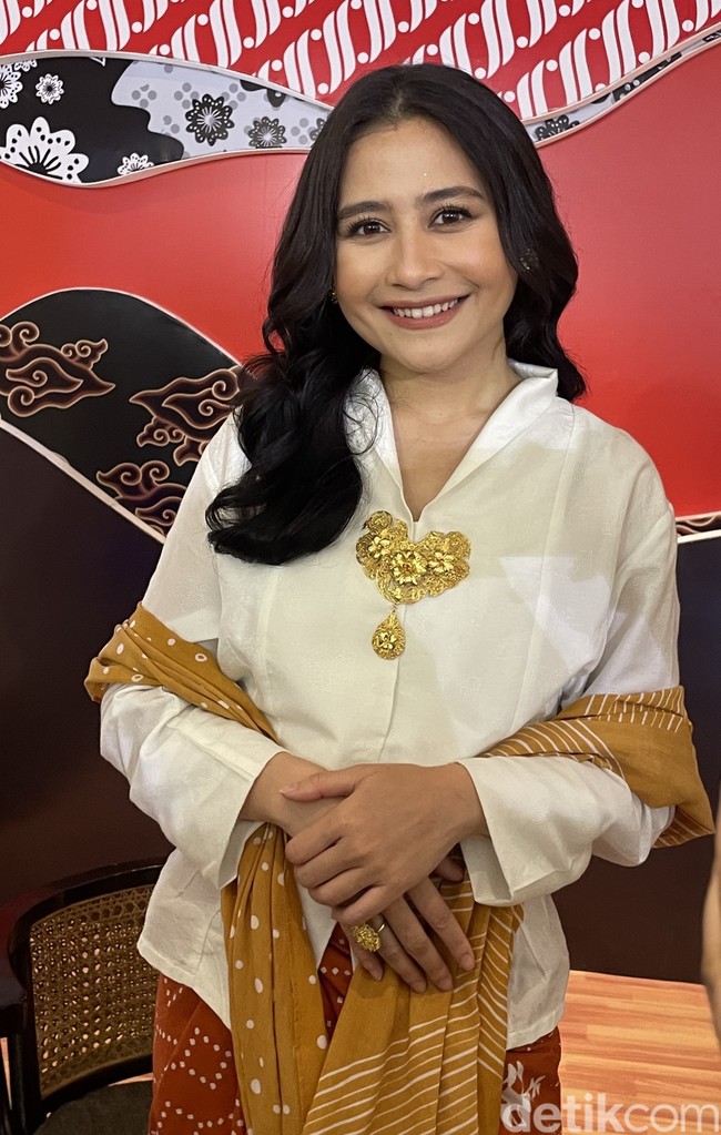 Wanita 27 tahun tersebut memadukan blus bersiluet kebaya dengan kain bernuansa oranye. Prilly juga menambahkan bros untuk menambah kesan tradisional. Foto: Rahmi Anjani/Wolipop