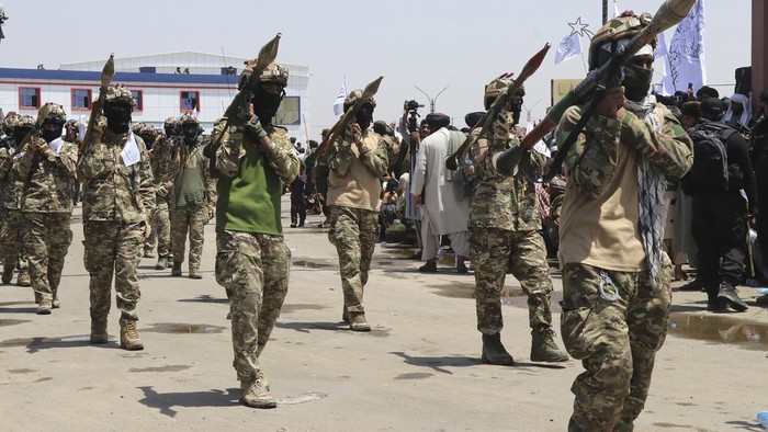 Taliban Pamer Senjata AS Saat Rayakan 3 Tahun Berkuasa di Afghanistan Taliban fighters carry dummy yellow canisters intended to represent homemade explosives, as they celebrate the third anniversary of the withdrawal of US-led troops from Afghanistan, in Lashkar Gah, Helmand province, southwestern Afghanistan, Wednesday, Aug. 14, 2024. (AP Photo/Abdul Khaliq)