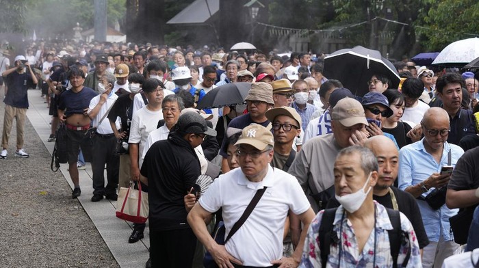 Warga Jepang Kunjungi Kuil Yasukuni Peringati 79 Tahun Perang Dunia II People observe a minute of silence at noon, while waiting in queue before reaching to the main hall to pray at Yasukuni Shrine, which honors Japan's war dead, in Tokyo, Japan, Thursday, Aug. 15, 2024, as the country marks the 79th anniversary of its defeat in the World War II. (AP Photo/Hiro Komae)