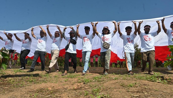 200 Mantan Napi Teroris Bentangkan Merah Putih di Poso Sejumlah mantan narpidana terorisme menarik bendera Merah Putih saat pembentangan di Gunung Biru, Desa Pantangolemba, Poso Pesisir Selatan, Kabupaten Poso, Sulawesi Tengah, Jumat (16/8/2024). Pembentangan bendera Merah Putih yang difasilitasi Satgas Madago Raya itu sebagai wujud komitmen para mantan teroris yang jumlahnya mencapai lebih dari 200 orang di wilayah itu terhadap NKRI sekaligus untuk memperingati HUT Ke-79 Republik Indonesa. ANTARA FOTO/Basri Marzuki/tom.