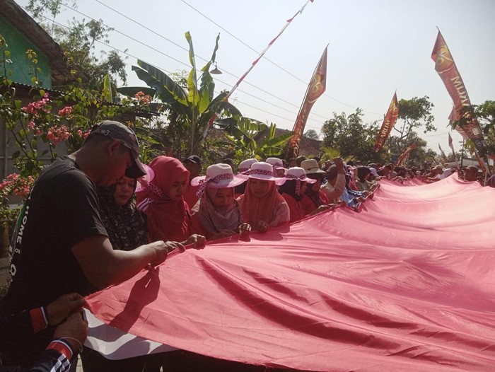 Aksi warga Desa Karangtengah, Kecamatan Ngawen, Blora, menjahit bendera merah putih 79 meter, Jumat (16/8/2024).