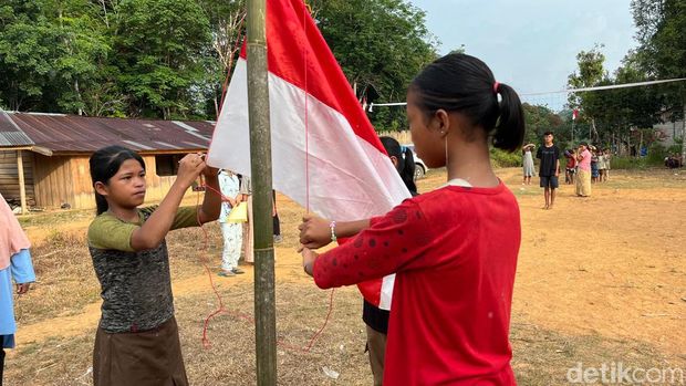 Anak Suku Talang Mamak berlatih mengibarkan bendera untuk upacara HUT RI.