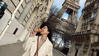 Ketika berada di depan Menara Eiffel, wanita berusia 32 tahun itu sempat berpose sambil menikmati satu potong ayam Turki yang berukuran jumbo. Foto: Instagram @jscmila