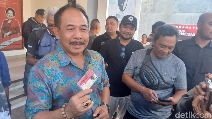 Ketua Banteng Muda Indonesia (BMI) Buleleng Ketut Putra Sedana mengembalikan kartu tanda anggota (KTA) dan seragam PDIP di Sekretariat DPC PDIP Buleleng pada Jumat (16/8/2024). (Foto: Made Wijaya Kusuma/detikBali)