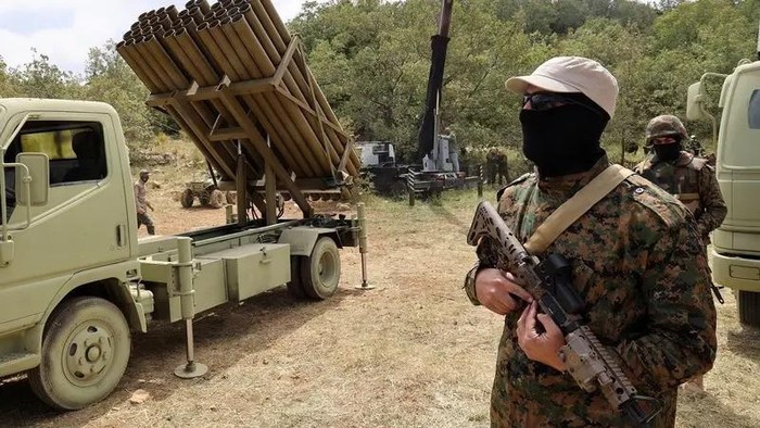 Lebanese Hezbollah fighters stand near a multiple rocket launcher during a press tour in the southern Lebanese village of Aaramta. (File photo: AFP)