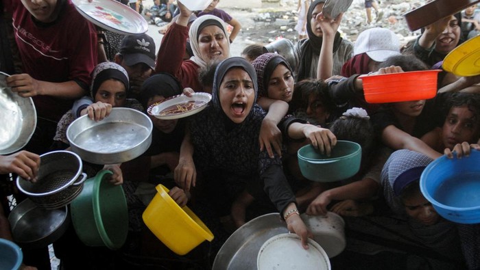 Potret Miris Anak-anak Gaza Terjepit Demi Dapat Makanan Palestinians react as they wait to receive food cooked by a charity kitchen, amid a hunger crisis as conflict between Israel and Hamas continues, in the northern Gaza Strip August 14, 2024. REUTERS/Mahmoud Issa TPX IMAGES OF THE DAY