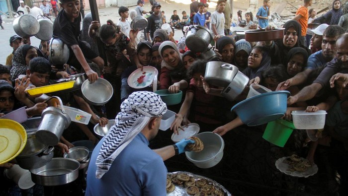 Potret Miris Anak-anak Gaza Terjepit Demi Dapat Makanan Palestinians react as they wait to receive food cooked by a charity kitchen, amid a hunger crisis as conflict between Israel and Hamas continues, in the northern Gaza Strip August 14, 2024. REUTERS/Mahmoud Issa TPX IMAGES OF THE DAY