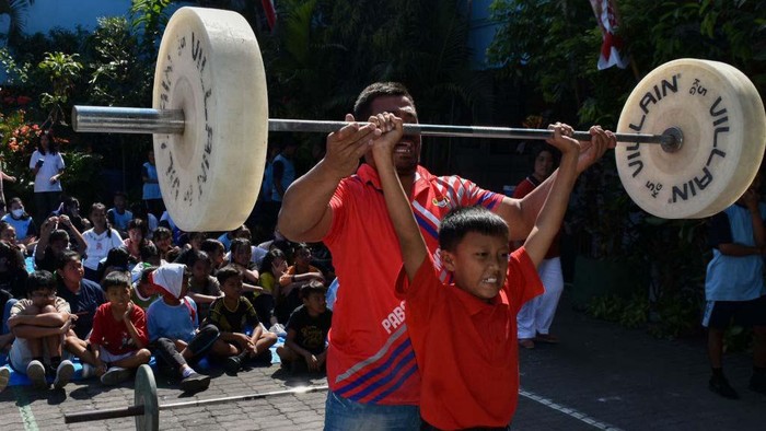 Rizki Juara Olimpiade, Angkat Beban Mencari Bibit Baru An athlete (in a red t-shirt) is teaching basic weightlifting techniques to students at SMP Petra Malang (Junior High School) in East Java, Indonesia, on August 15, 2024. The Road Show Weightlifting sports event is visiting several schools to find new athletes after Indonesia won the weightlifting gold medal at the 2024 French Olympics. (Photo by Aman Rochman/NurPhoto via Getty Images)