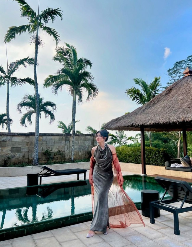 Menjadi salah satu bridesmaid di pernikahan sahabatnya yang digelar di Amanjiwo, Jawa Tengah, Shaloom memilih tampil dengan gaya unik namun tetap stylish. Anak sulung Wulan Guritno itu tampil dengan memadukan dress velvet hijau dan sarung tangan unik berwarna merah. Foto: Instagram/@sharazaaa