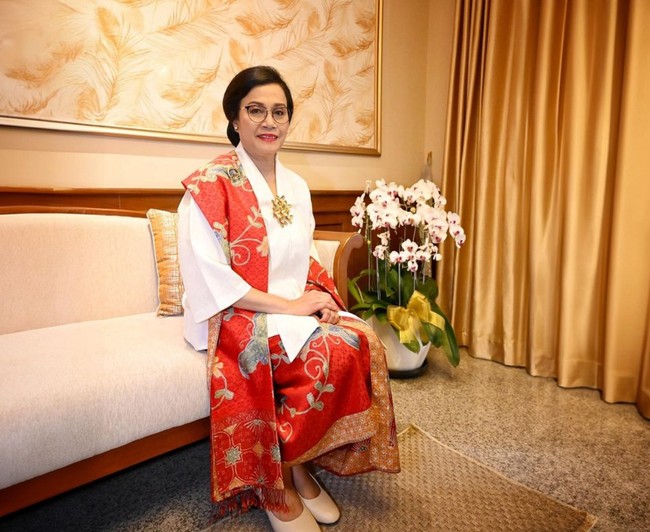 Sri Mulyani tampak anggun mengenakan atasan kebaya berpotongan longgar yang dipadukan kain batik merah motif floral. Tak lupa selendang bermotif dan warna senada melengkapi penampilannya. Foto: Instagram/@smindrawati