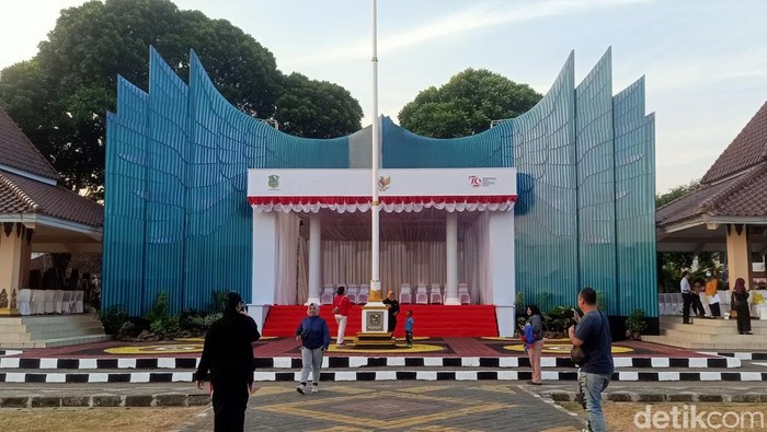 Warga berfoto di depan panggung upacara HUT ke-79 RI di Alun-alun Banjarnegara yang didesain mirip Istana Garuda IKN, Jumat (16/8/2024).