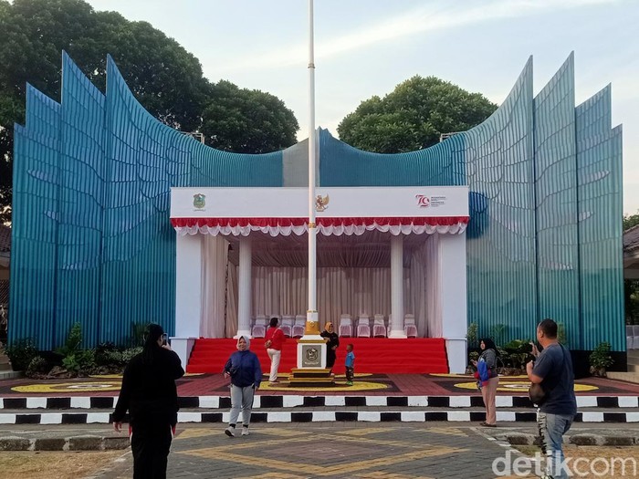 Warga berfoto di depan panggung upacara HUT ke-79 RI di Alun-alun Banjarnegara yang didesain mirip Istana Garuda IKN, Jumat (16/8/2024).