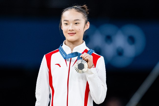 Atlet Zhou Yaqin sempat viral di Olimpiade Paris 2024 karena sikapnya yang menggemaskan saat meraih medali perak. Saat menang juara dua dalam cabor senam artistik, ia jadi sorotan karena mengikuti pose dua pemenang lain yang menggigit medali mereka di podium.  Foto: Tom Weller/VOIGT/GettyImages