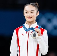 Atlet Zhou Yaqin sempat viral di Olimpiade Paris 2024 karena sikapnya yang menggemaskan saat meraih medali perak. Saat menang juara dua dalam cabor senam artistik, ia jadi sorotan karena mengikuti pose dua pemenang lain yang menggigit medali mereka di podium.  Foto: Tom Weller/VOIGT/GettyImages