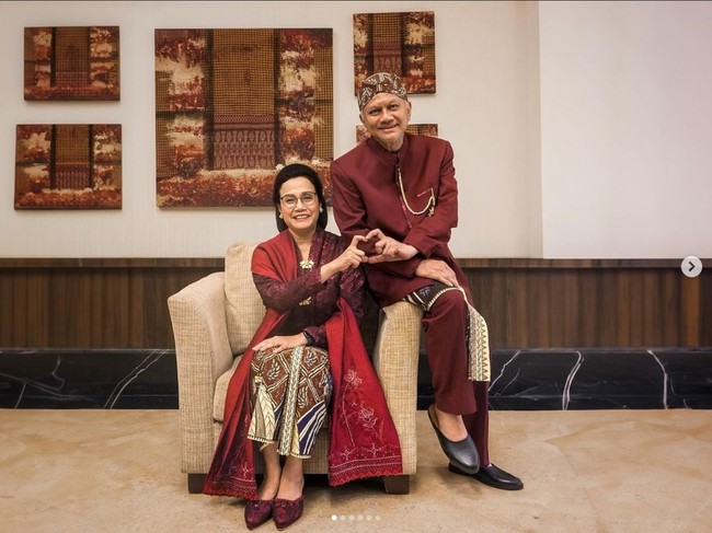 Sri Mulyani memadukan kain batik dengan kebaya merah, selendang merah selop merah. Suaminya, Tonny Sumartono juga memakai busana serba merah, beskap dan dan celana merah dengan kain senada dengan sang istri. Foto: Dok. Instagram Sri Mulyani