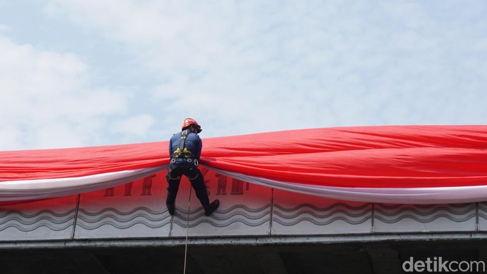 Petugas Diskar PB Kota Bandung saat membentangkan bendera merah putih raksasa di flyover Mochtar Kusumaatmadja