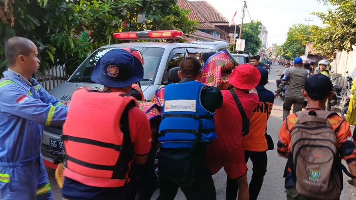 Petugas gabungan saat membawa jenazah pelajar SMP yang tenggelam di Sungai Lematang ke rumah duka.
