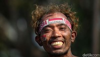 Senyum salah satu peserta lomba panjat pinang di Ancol. 