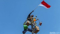 Seorang peserta berhasil mencapai puncak pohon pinang. 
