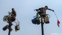 Beragam hadiah, mulai dari barang elektronik hingga sepeda digantung di puncak batang pinang. 