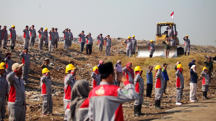 Petugas Dinas Lingkungan Hidup dan Kebersihan Sidoarjo mengikuti upacara peringatan HUT ke-79 Kemerdekaan RI di TPA Griyo Mulyo Jabon, Sidoarjo, Jawa Timur, Sabtu (17/8/2024). Upacara HUT ke-79 RI yang mengusung tema Nusantara Baru, Indonesia Maju tersebut diikuti puluhan petugas kebersihan dan sejumlah karyawan. ANTARA FOTO/Umarul Faruq/wpa.