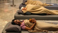 Seorang peserta mengikuti lomba tidur dengan membawa boneka. 