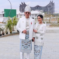 Menteri Agraria dan Tata Ruang Agus Harimurti Yudhoyono (AHY) tampil serasi dengan istrinya, Annisa Yudhoyono dalam balutan busana pernikahan Suku Banjar. “Pakaian ini biasa dipakai oleh pengantin dari Suku Banjar yang memiliki ciri khas aplikasi warna dan detail yang gemerlap, sehingga seolah bermandikan sinar matahari,” tulis AHY di Instagram. Annisa makin berkilau dengan padanan tas mewah Hourglass Balenciaga berwarna senada. (Foto: Kementerian ATR/BPN)