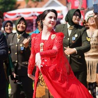 Kebaya rancangan desainer Diana M Putri itu tampak memiliki kain seperti jubah pada bagian belakangnya. Atasan kebaya merah itu kemudian dipadukan dengan bawahan kain batik coklat. Foto: Instagram/@arumibachsin_94