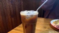 Sebagai pendamping, kamu bisa memesan es kopi yang punya racikan unik ini. Tampilannya mirip seperti iced Americano, tapi ditambah dengan sirup manis yang rasanya mirip seperti sirup markisa. Foto: Detikcom / Atiqa Rana