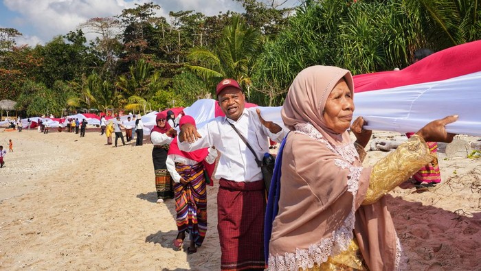 Ratusan warga Desa Wowong, Kecamatan Omesuri, Kabupaten Lembata, NTT, membentangkan bendera merah putih sepanjang satu kilometer, dalam rangka memeriahkan Hari Ulang Tahun (HUT) Ke-79 Republik Indonesia, di bibir Pantai Nusantara, Nusa Tenggara Timur.