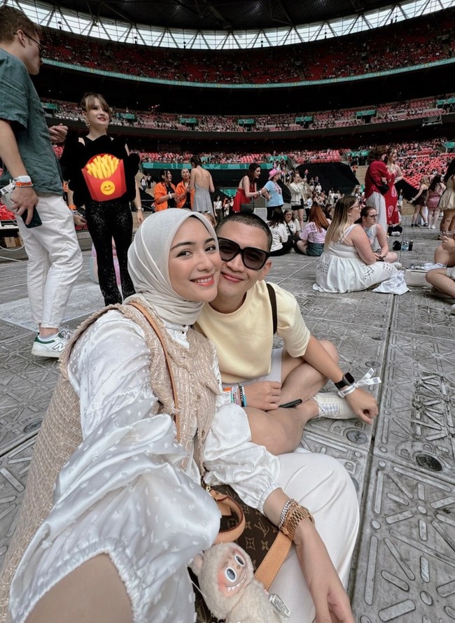 Tampil bak ABG, Citra terlihat mengenakan blouse lengan panjang satin berwarna putih dipadukan dengan celana panjang putih dan rompi coklat. Penampilannya juga dilengkapi dengan hijab berwarna senada. Sementara Rezky terlihat simpel dan santai dengan kaos berwarna krem dan celana pendek. Foto: Instagram/@citraciki